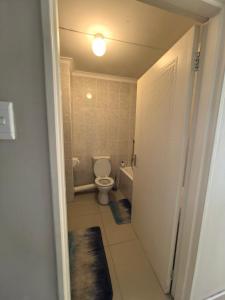 a bathroom with a toilet and a light on the ceiling at SinoT Short Stays in Pietermaritzburg