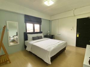 a bedroom with a large bed with a window at Baan Ploy In in Chiang Mai