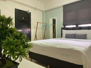 a bedroom with a large bed with a black headboard at Baan Ploy In in Chiang Mai