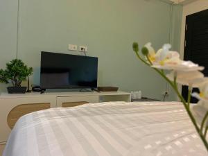 a bedroom with a bed and a flat screen tv at Baan Ploy In in Chiang Mai