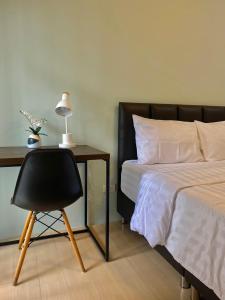 a bedroom with a bed and a desk with a chair at Baan Ploy In in Chiang Mai
