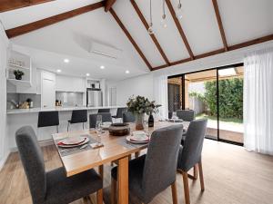 a dining room and kitchen with a wooden table and chairs at Clearwater Escape Dunsborough in Dunsborough