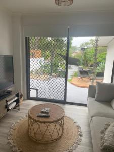 ein Wohnzimmer mit Couch und Tisch in der Unterkunft Bee Cottage in Gold Coast