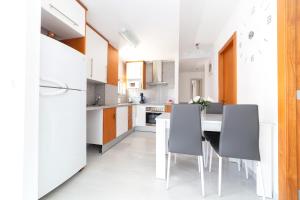 a kitchen with white appliances and a table and chairs at Apartamento Elegance Benidorm La Cala in Benidorm