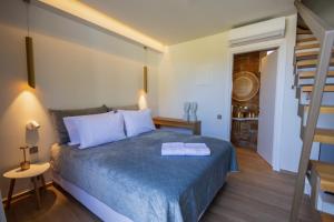 a bedroom with a blue bed and a ladder at Oikos Sani Suites in Sani Beach