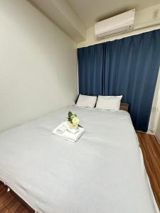 Una gran cama blanca con una bandeja de flores encima. en SOLASIA residence 北上野601, en Tokio