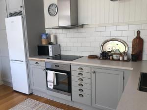 a kitchen with a stove and a white refrigerator at The Guest House. in Gammelstaden