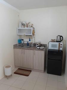 eine Küche mit Theke, Spüle und Mikrowelle in der Unterkunft Condo in Pasig in Manila + 2 Fotos