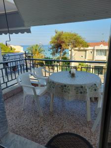 a table and chairs on a balcony with a view of the ocean at Spyros Studio in Paleo Tsifliki