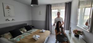 a man and a woman standing in a bedroom at Doris Hotel in Siófok