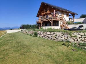 a house on a hill with a stone wall at les balcons de Serre-Poncon in Chorges