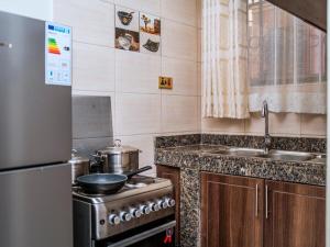 a small kitchen with a stove and a sink at Jengel Studio Apartments Entebbe 1 in Entebbe