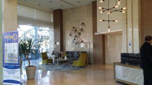 イロイロにあるmegaworld iloilo city, one madison luxury residencesの黄色い椅子とテーブルのあるロビー +2枚の写真