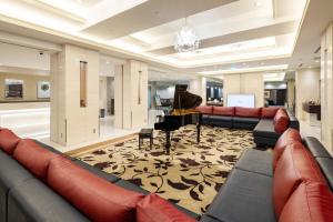 a large living room with couches and a piano at Hotel Metropolitan Takasaki in Takasaki
