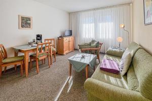 a living room with a couch and a table at Villa Viktoria Whg 5 - "Moosmuschel" in Kolpinsee