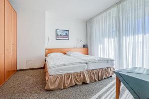 a bedroom with a bed and a large window at Villa Viktoria Whg 5 - "Moosmuschel" in Kolpinsee