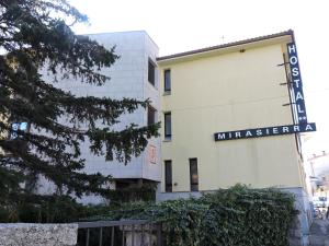 un bâtiment avec un panneau sur son côté dans l'établissement Mirasierra, à Bustarviejo