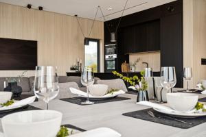 a dining table with wine glasses on top of it at Luxury Cabin in beautiful Lofoten with Jacuzzi and sauna in Kleppstad