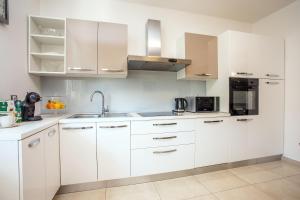 a white kitchen with white cabinets and appliances at Villa Knez in Gata