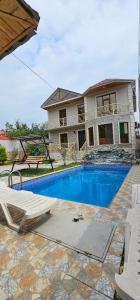 a swimming pool in front of a house at Villa RML Montainside CYHN in Gabala