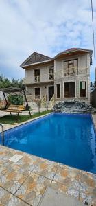 a house with a swimming pool in front of a house at Villa RML Montainside CYHN in Gabala