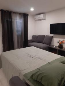 a bedroom with a bed and a couch at Max in Vodice