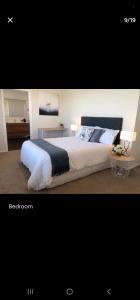 a bedroom with a large bed with two lamps at Stunning Seaviews in Wellington