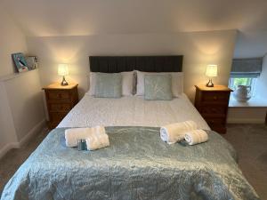 a bedroom with a bed with two towels on it at May Cottage in Bridlington