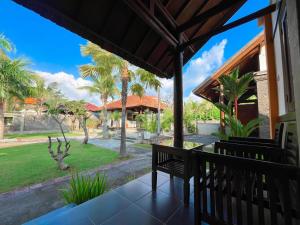 a porch with two benches and a view of a park at Prabhu Suites in Lovina