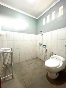 a bathroom with a toilet and a shower at Prabhu Suites in Lovina
