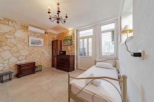 a bedroom with a bed and a stone wall at Olive Grove House in Ston +174 photos