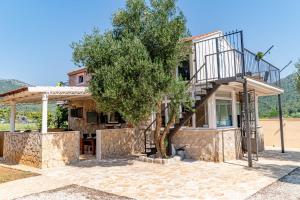 a villa with a tree and a house at Olive Grove House in Ston