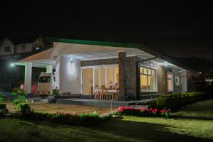 a small house at night with a table at Lulu's Bungalow in Nuwara Eliya