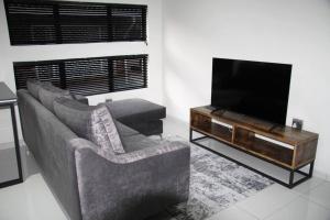 a living room with a couch and a flat screen tv at KT Space in Midrand