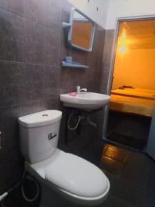 a bathroom with a white toilet and a sink at New Samanali Resort in Kataragama