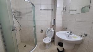 a bathroom with a shower and a toilet and a sink at Marina Bay Apartmant in Pomorie
