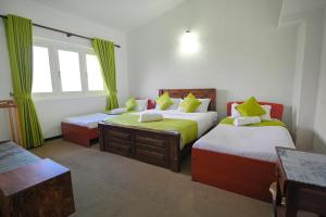 a bedroom with two beds and a window at Lulu's Bungalow in Nuwara Eliya +6 photos