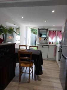 a kitchen with a table and two chairs and a kitchen with a counter at Douce Escale - Agen sud, T2, RDJ, clim réversible, proche ENAP in Agen