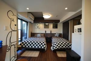 una habitación con dos camas en una habitación en 島内小宿, en Osaka