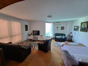 a bedroom with a bed and two chairs and a tv at Apartmani Maver in Sveti Filip i Jakov