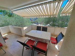 a patio with a table and chairs in a room at Apartmani Maver in Sveti Filip i Jakov