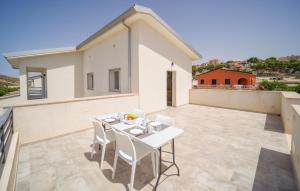 a white table and chairs on the balcony of a house at Gorgeous Home In Realmonte With Kitchen in Realmonte
