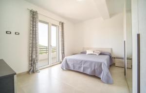 a white bedroom with a bed and a large window at Gorgeous Home In Realmonte With Kitchen in Realmonte