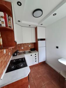 a kitchen with white cabinets and a stove at Przytulny 2-pokojowy apartament na wakacje w Gdańsku in Gdańsk +10 photos