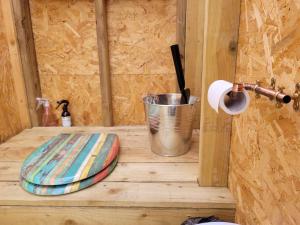 大圣科勒姆Lakeside Glamping Firecrest的木制架子上的马桶座圈和水桶