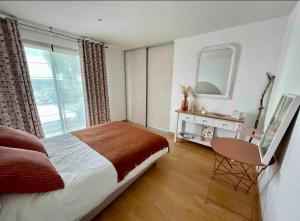 Un dormitorio con una cama, un escritorio y un espejo. en Villa Roch Ana, en Plouézocʼh
