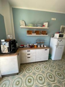 a kitchen with a white refrigerator and a counter at Trentatre Quarantatre in Mola di Bari