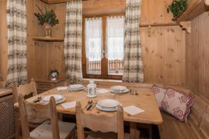 uma sala de jantar com uma mesa de madeira e cadeiras em Appartamento Baita Cusini Saroch em Livigno