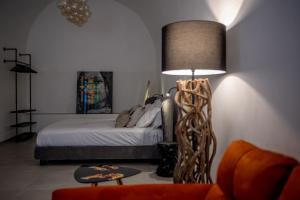 a bedroom with a bed and a table with a lamp at Marì Luxury House in Noto