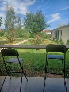 two chairs sitting on a porch looking out of a window at maison en ville au calme in Fleurance